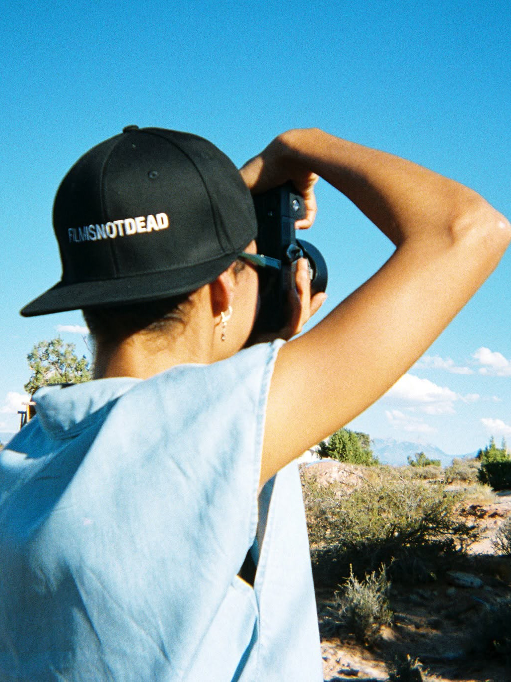 Asia Pimentel photographing a landscape under a clear blue sky