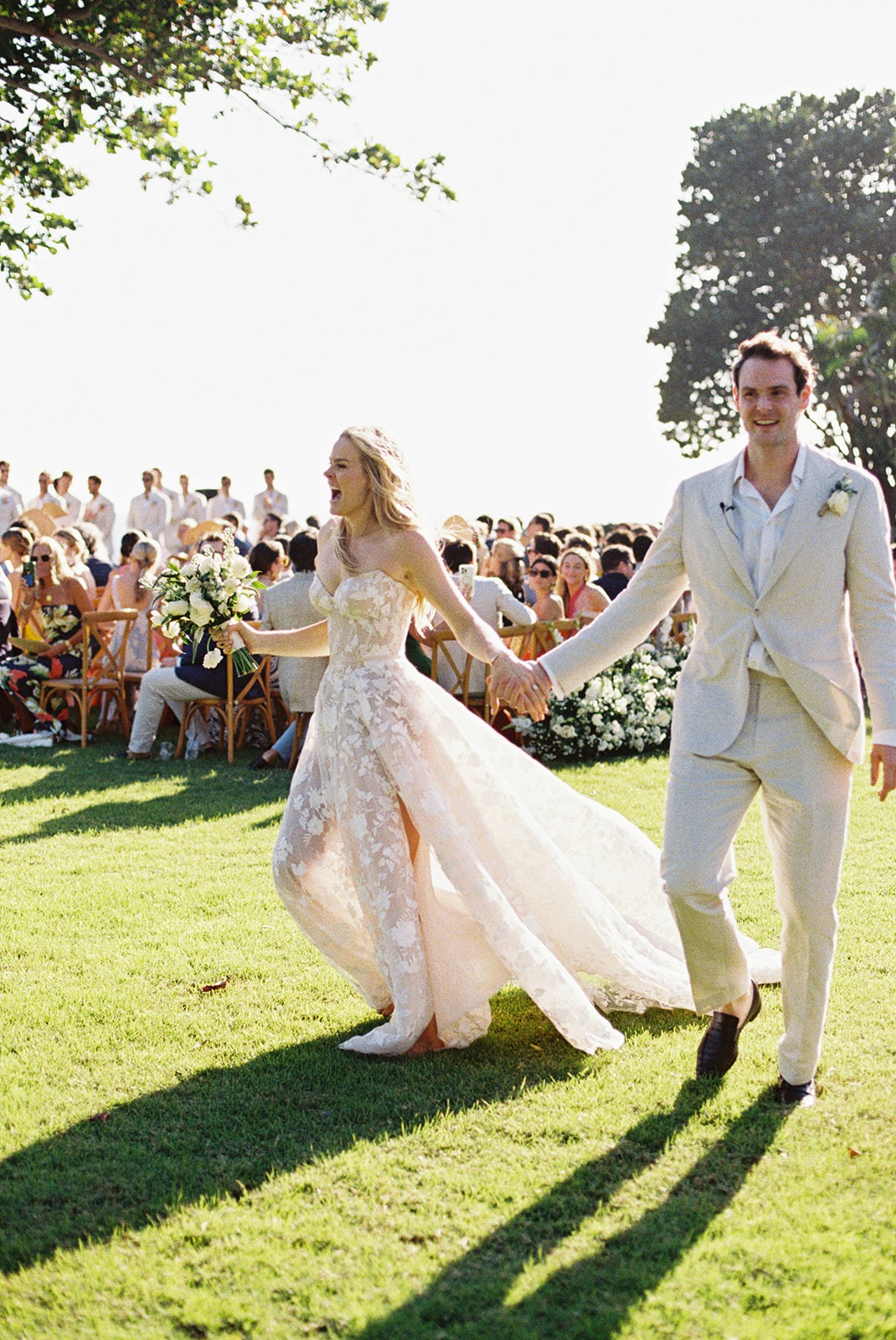 Newlyweds walking across lawn, Lauren & August's Casa de Campo wedding, Dominican Republic