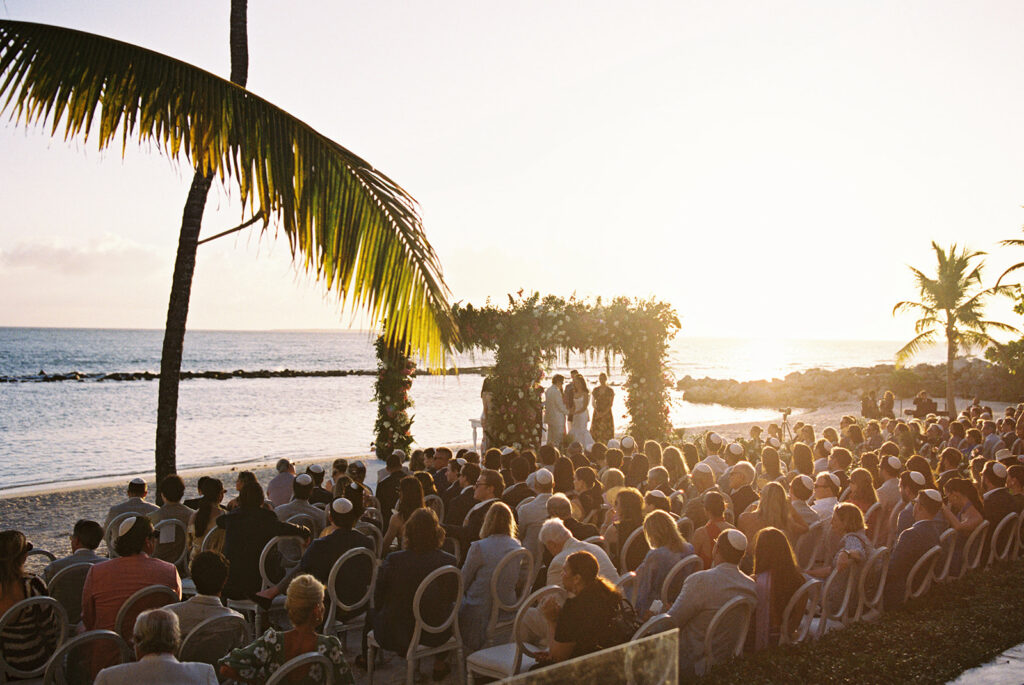 Beach ceremony at sunset framed by palm trees, Minitas Beach, Casa de Campo, Dominican Republic