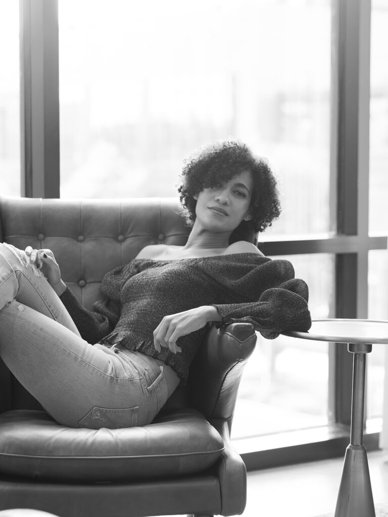 Asia Pimentel, Dominican Republic wedding and portrait photographer, in a leather armchair by the window