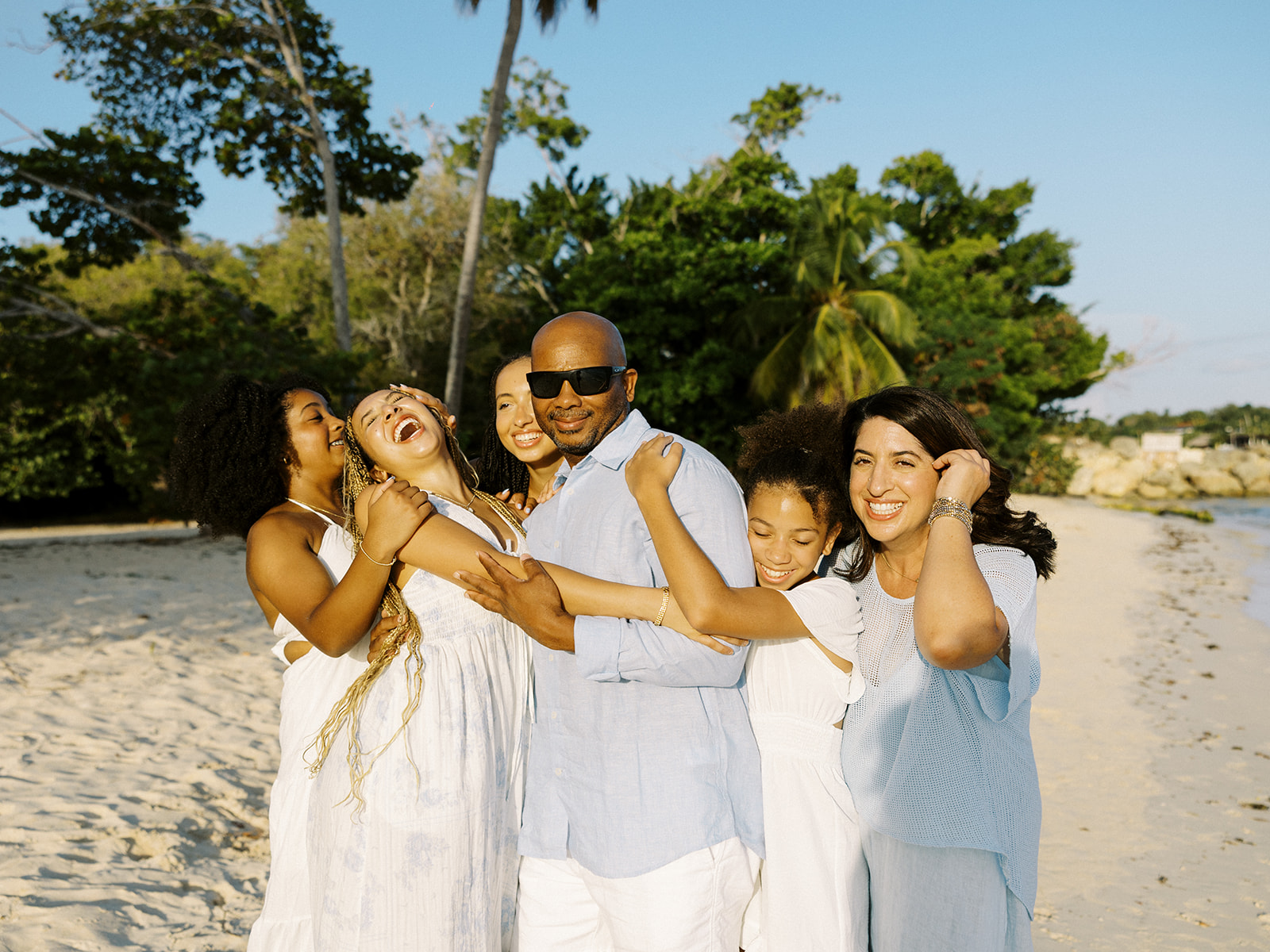 Parents and daughters share playful beach moment during family portrait at Casa de Campo, Dominican Republic