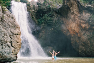 Couple shares a playful moment at Salto Baiguate waterfall in Jarabacoa, Dominican Republic