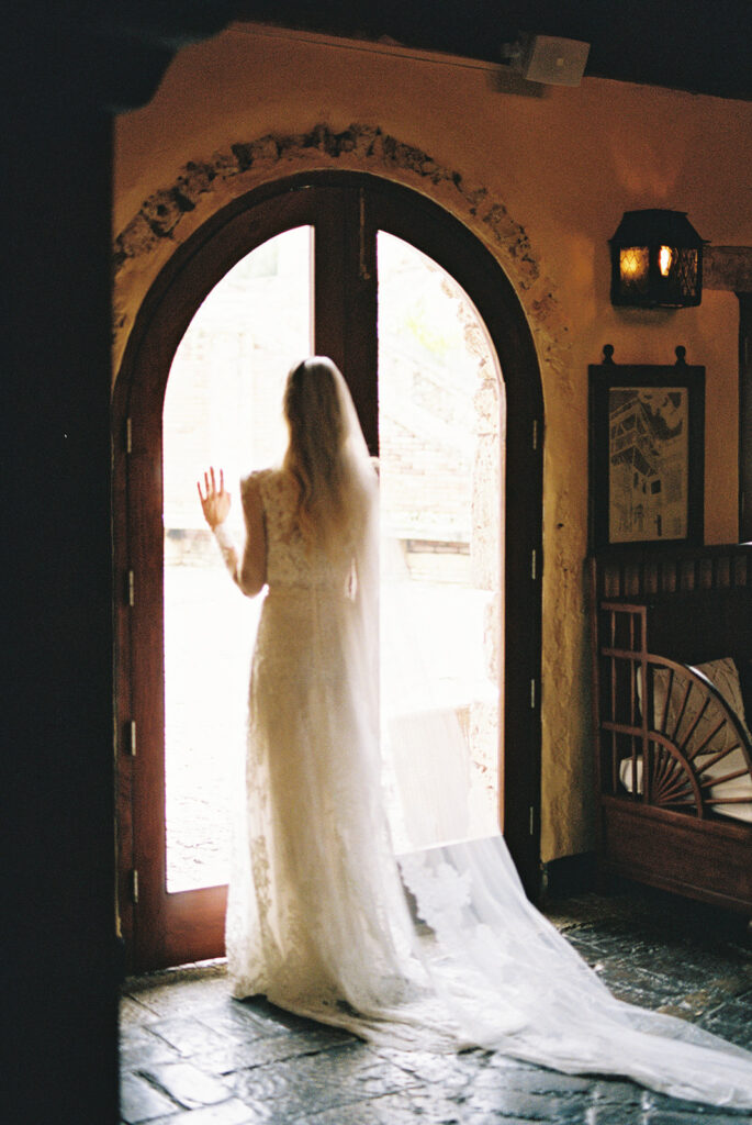 Bride standing in the arched doorway before the ceremony, Altos de Chavón, Dominican Republic