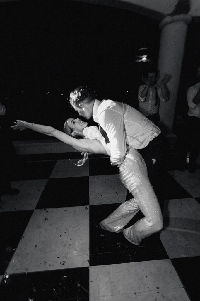 Black and white photo of the groom dipping the bride low on the dance floor, Casa de Campo wedding