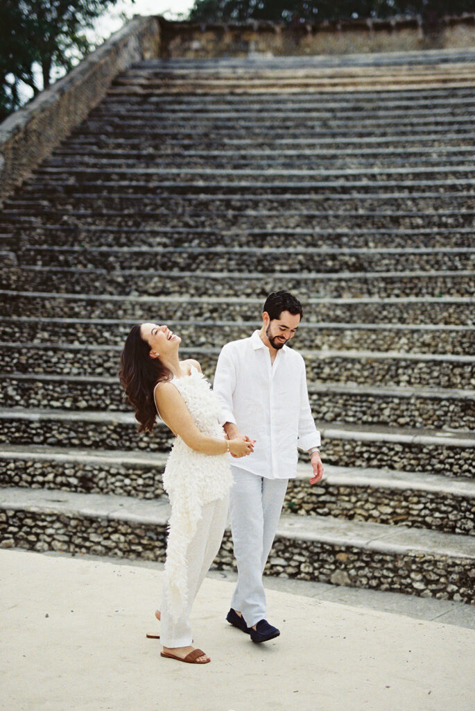 Couple laughing and walking together during engagement session at Casa de Campo amphitheater