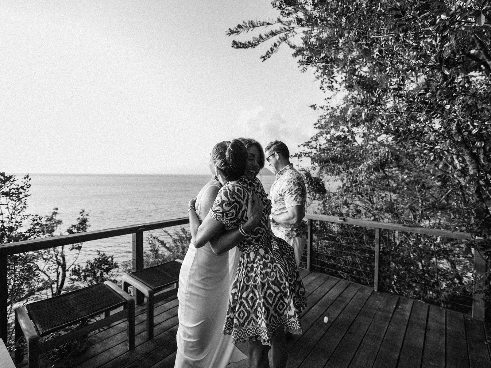 Two guests embracing on the cliffside path, black and white