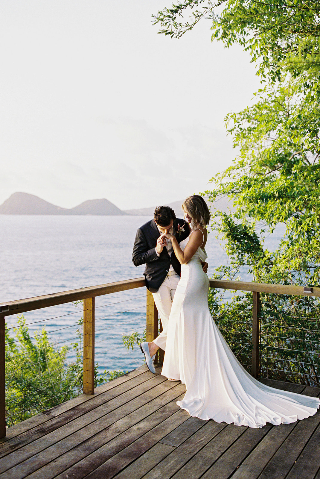 Aaron kissing Elizabeth's hand, cliffside ocean view