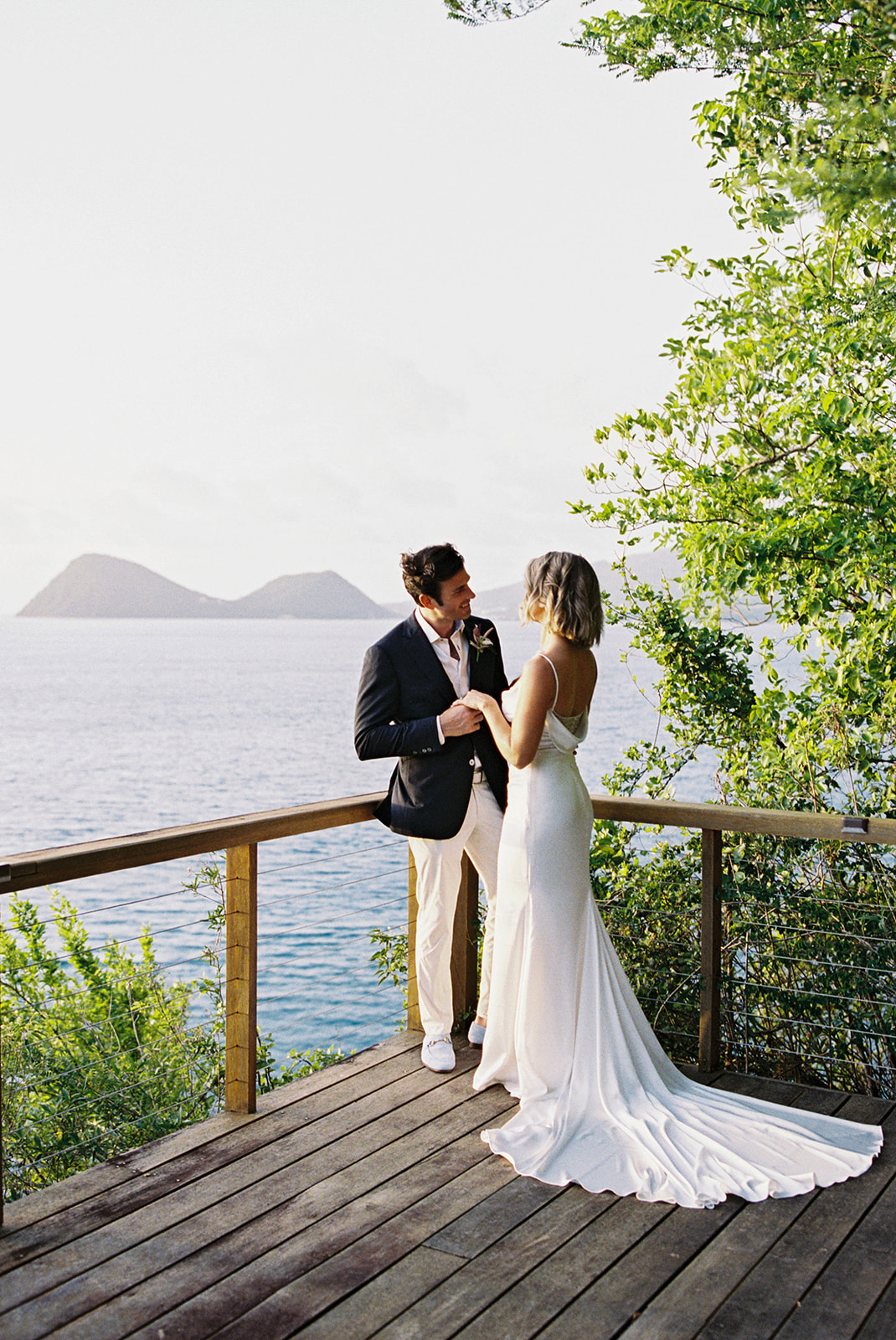 Elizabeth and Aaron standing together on the cliffside, holding hands