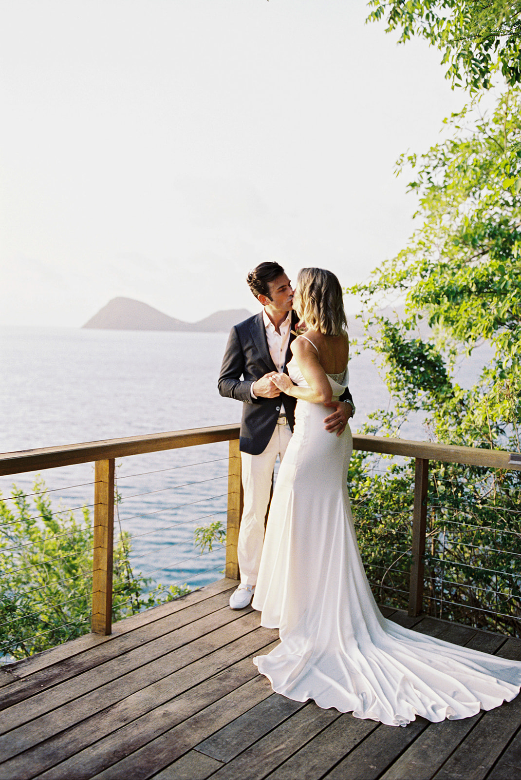 Elizabeth and Aaron embracing, ocean view behind them