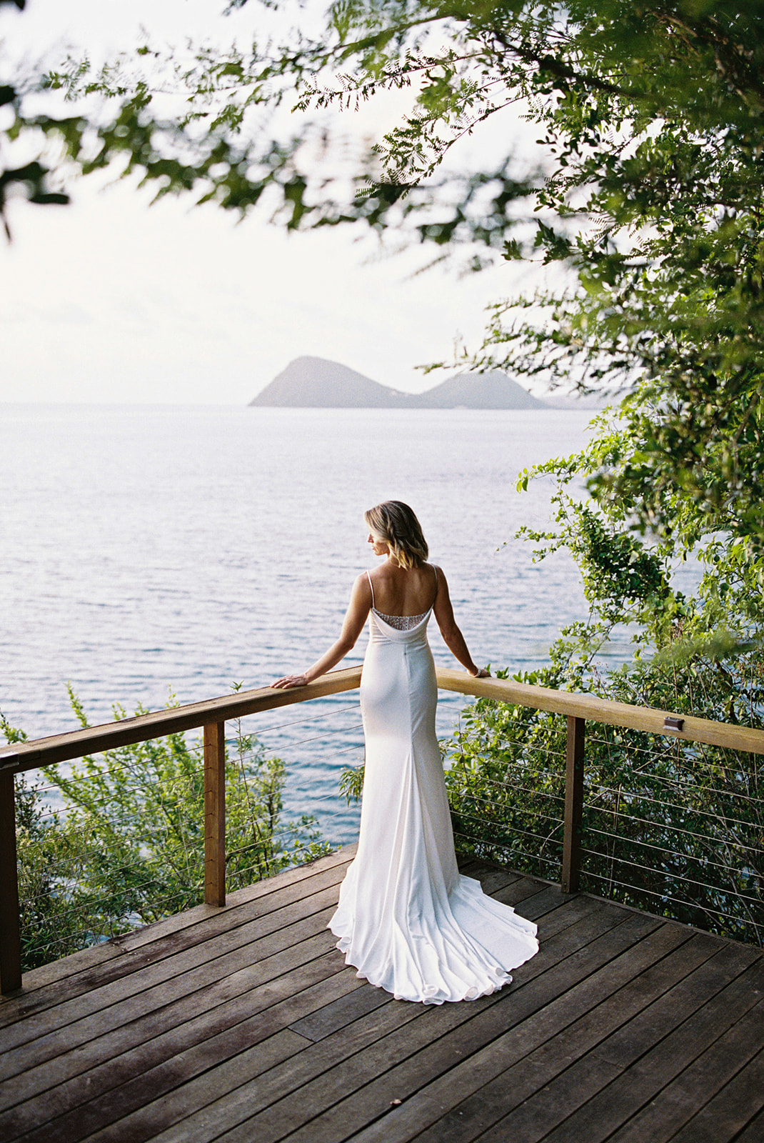 Elizabeth alone on the cliffside terrace, looking out at the ocean